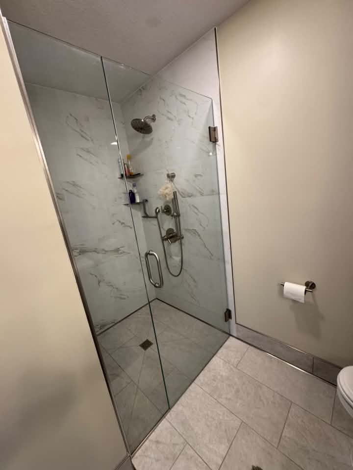 Shower installation with glass door and cream walls in MN 